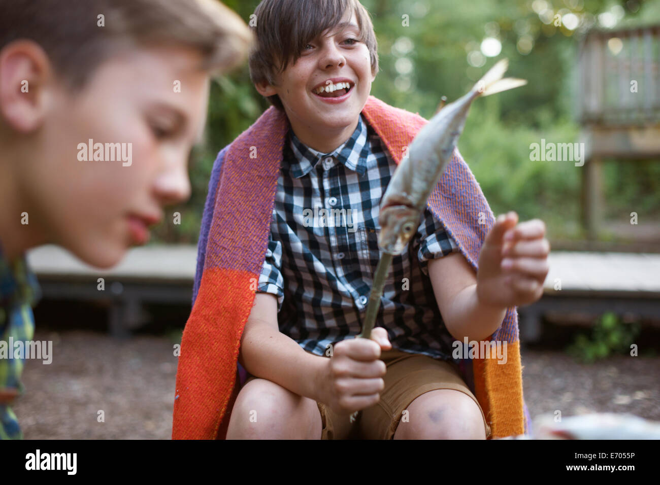 Ragazzo giovane azienda stick con pesce su pronto a barbecue Foto Stock
