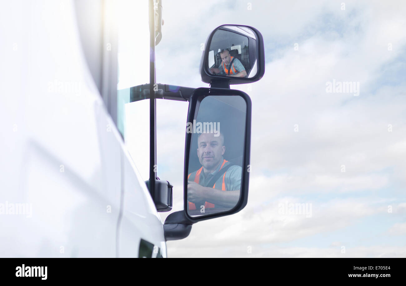 Camionista riflette in specchietto laterale Foto Stock