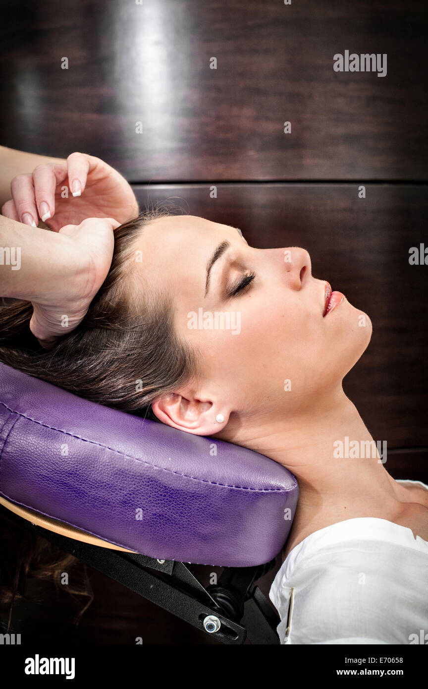 Massaggiatore femminile giovane massaggio testa di donna nel salone di bellezza Foto Stock