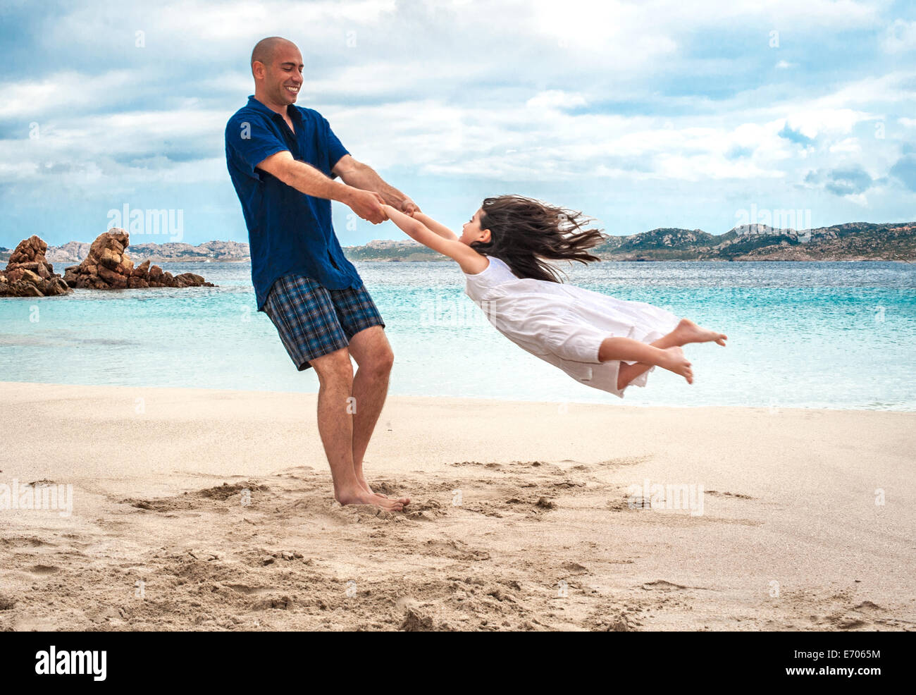 Metà uomo adulto figlia oscillante sulla spiaggia, La Maddalena, in Sardegna, Italia Foto Stock