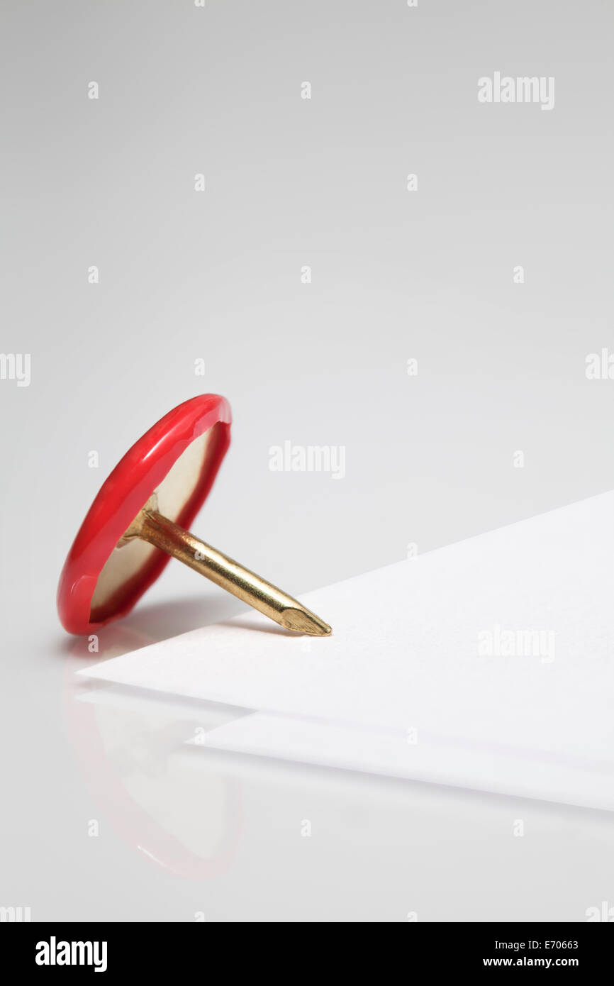 Close up di puntina da disegno su un angolo della carta vuoto Foto Stock