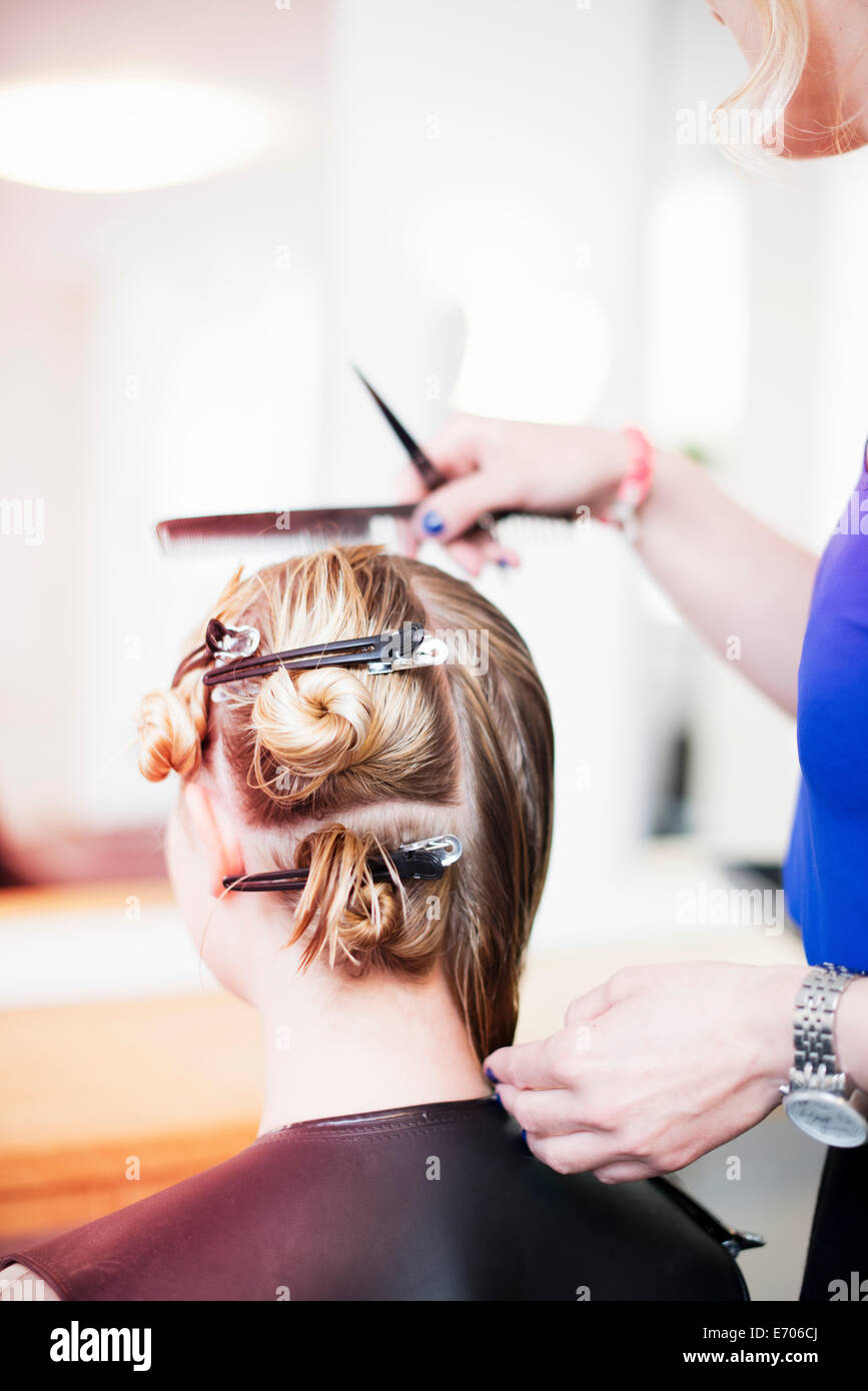 Donna con capelli fermi nei capelli in salone Foto Stock