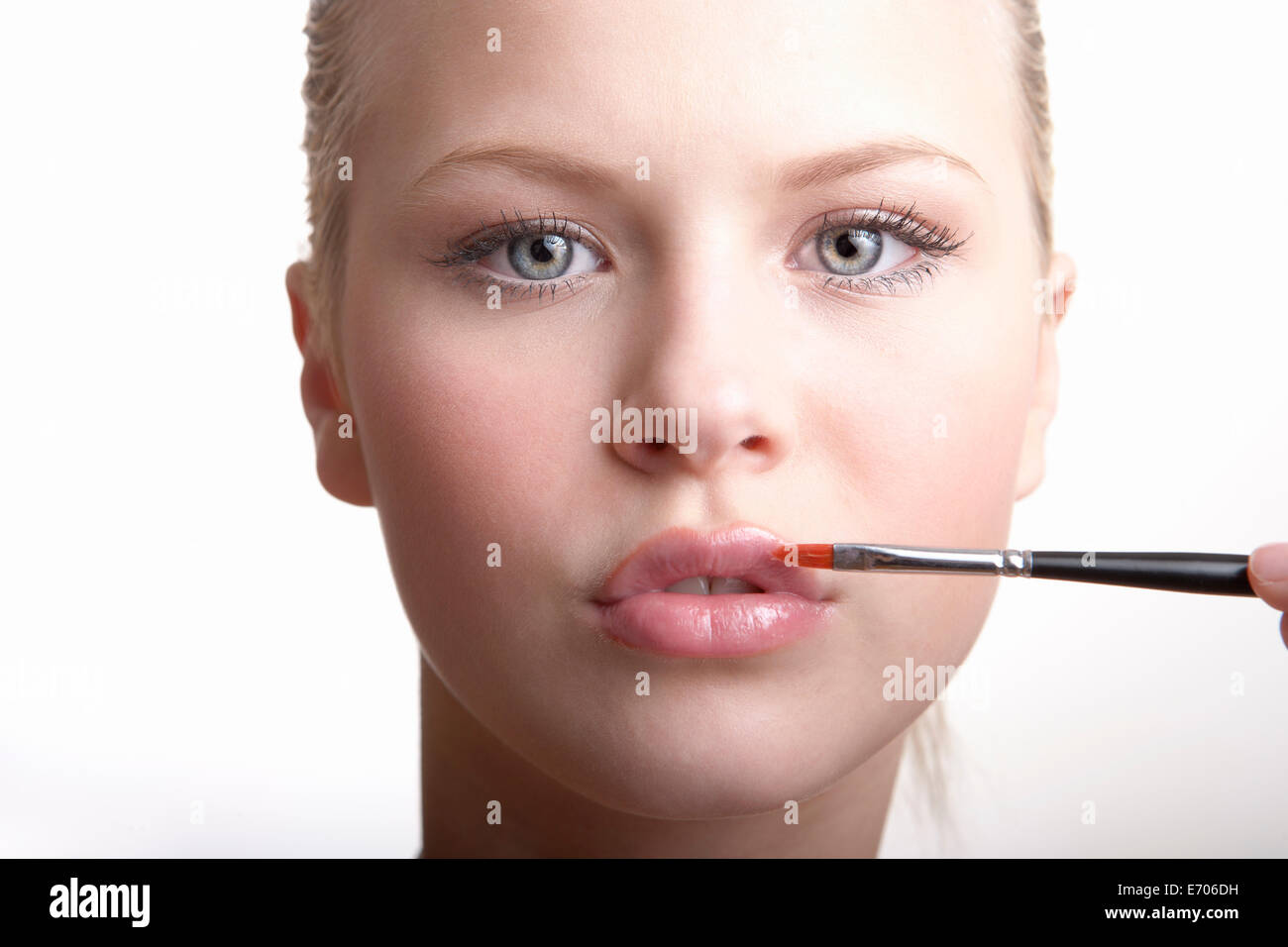 Ragazza adolescente applicando lip gloss Foto Stock
