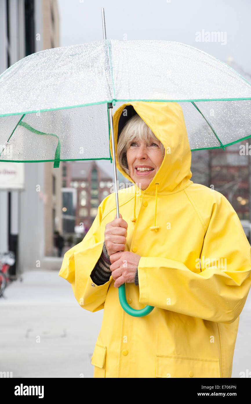 Persona anziana sotto la pioggia con un ombrello Foto stock - Alamy