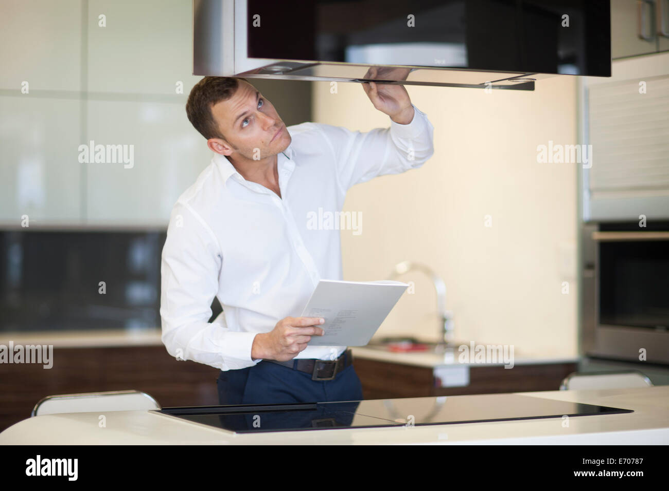 Metà uomo adulto ispezione cappa in cucina showroom Foto Stock