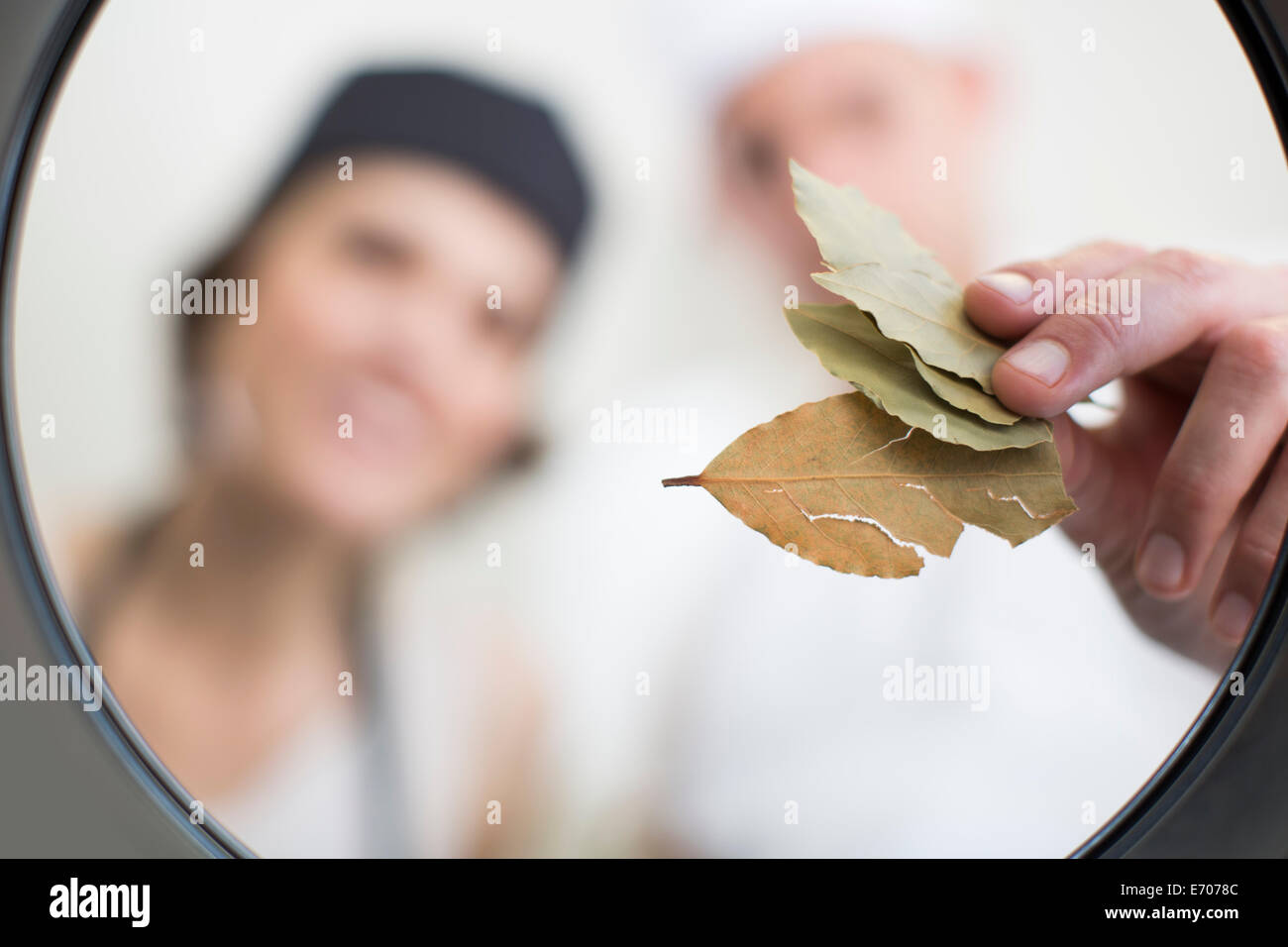 Chef mettendo le foglie di alloro nella pentola in cucina commerciale Foto Stock