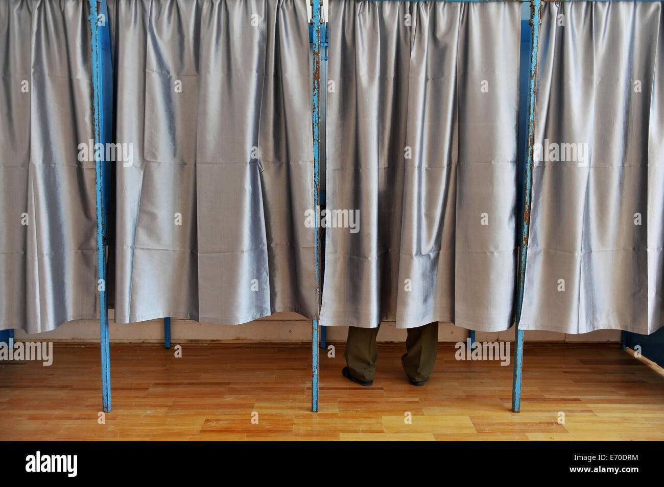 Un uomo la fusione il suo voto all'interno di una cabina di voto Foto Stock