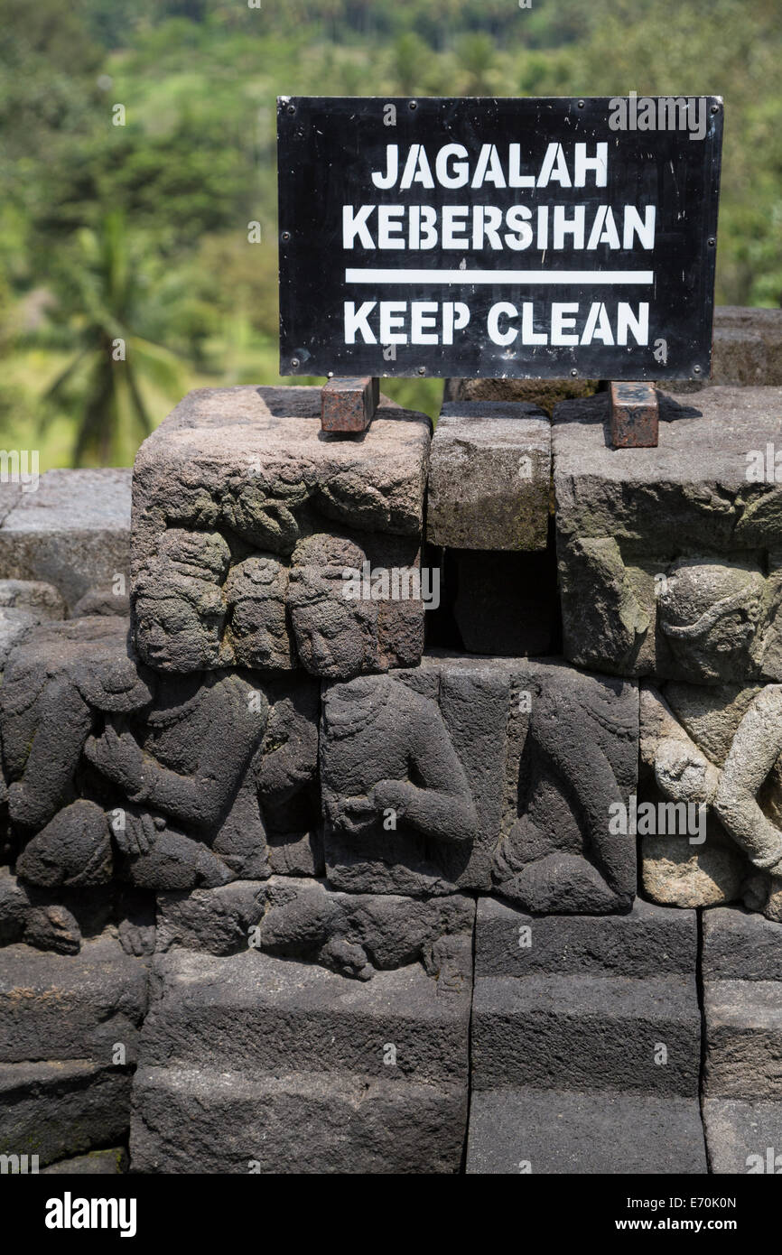 Borobudur, Java, Indonesia. "Keep Clean' (No il littering) firmare al di sopra della pietra che intaglia nella parete superiore del tempio di Borobudur. Foto Stock
