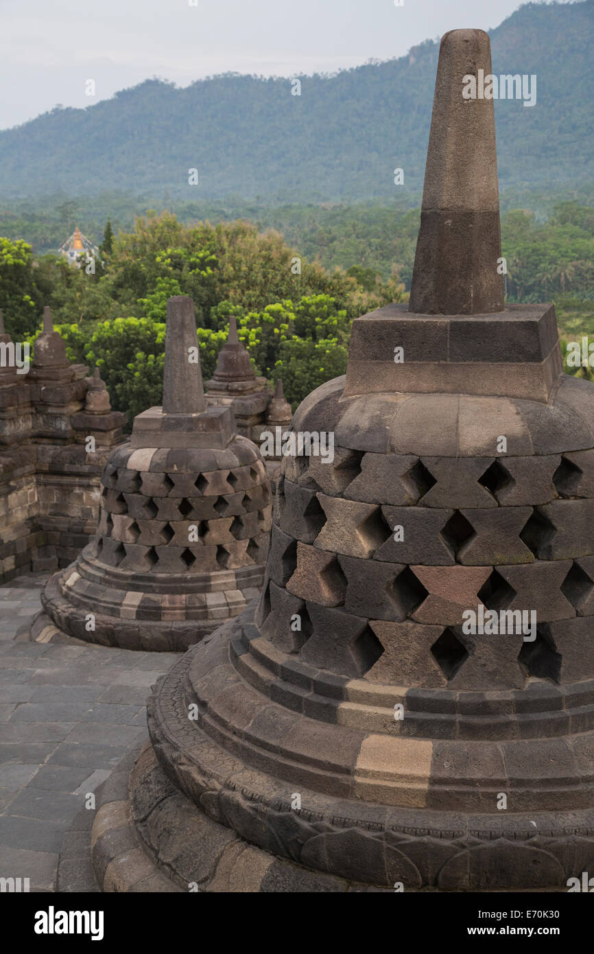 Borobudur, Java, Indonesia. Gli stupa vicino alla parte superiore del tempio di Borobudur. Le forme dei diamanti simboleggiano il persistente passioni. Foto Stock