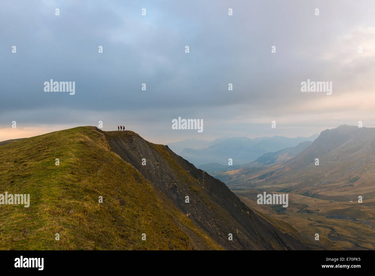 Tre escursionisti sulla cresta di una montagna in degli Ecrins al crepuscolo, Dauphiné Alpi, Savoie, Francia Foto Stock