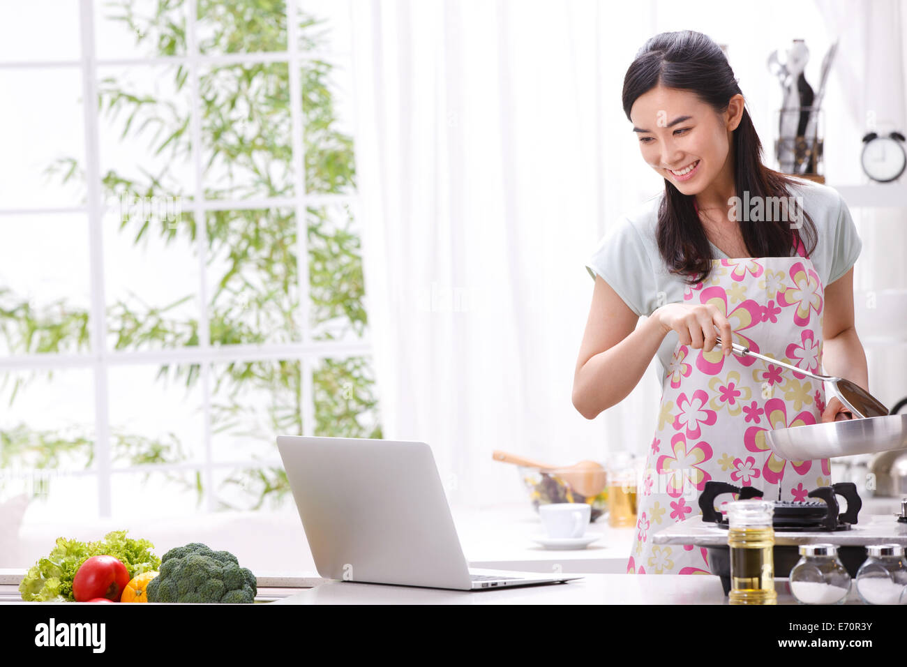 Giovane donna imparare la cottura in cucina Foto Stock