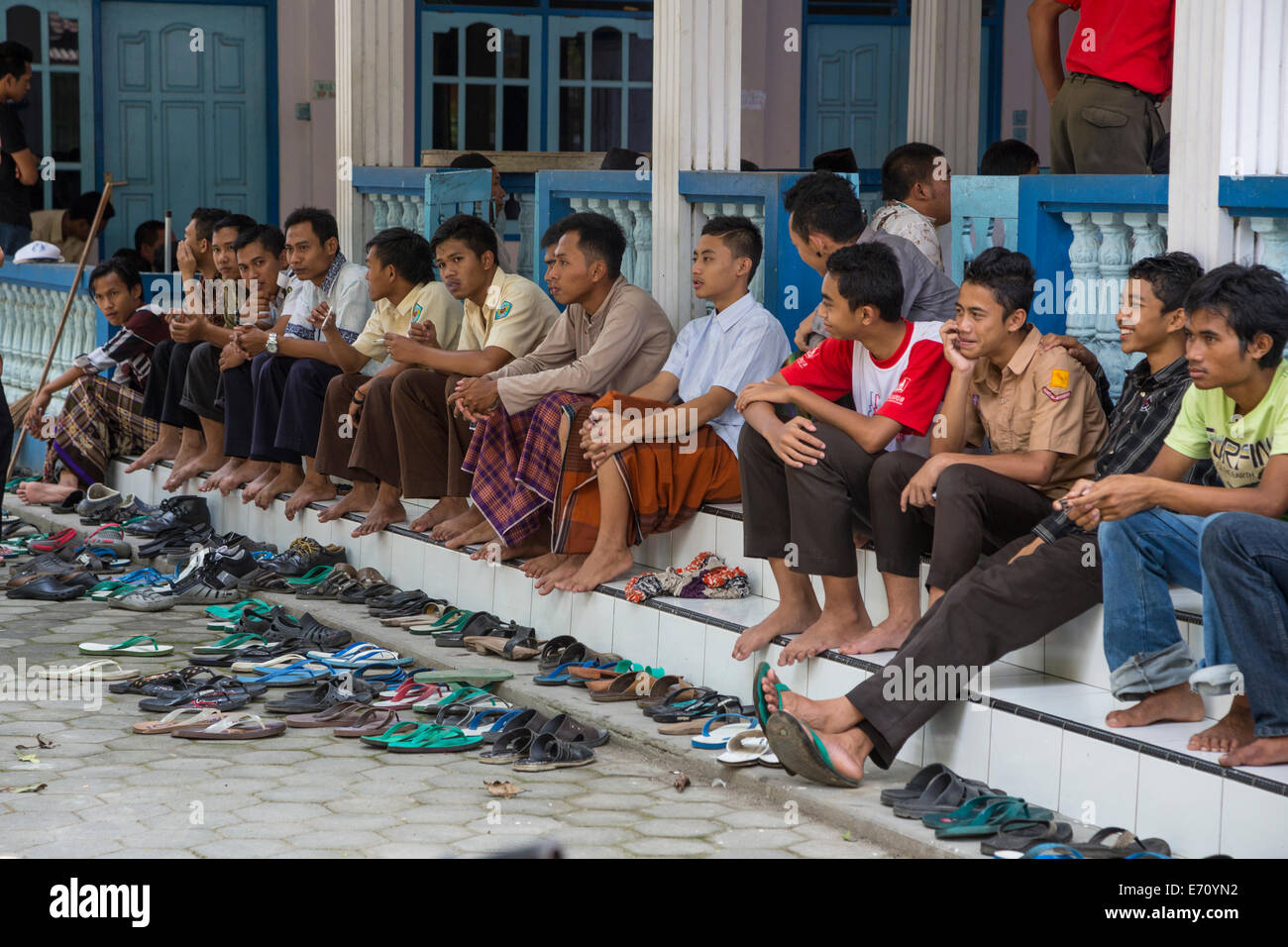 Borobudur, Java, Indonesia. Giovani uomini in attesa di venerdì a mezzogiorno la preghiera in una moschea di quartiere. Foto Stock