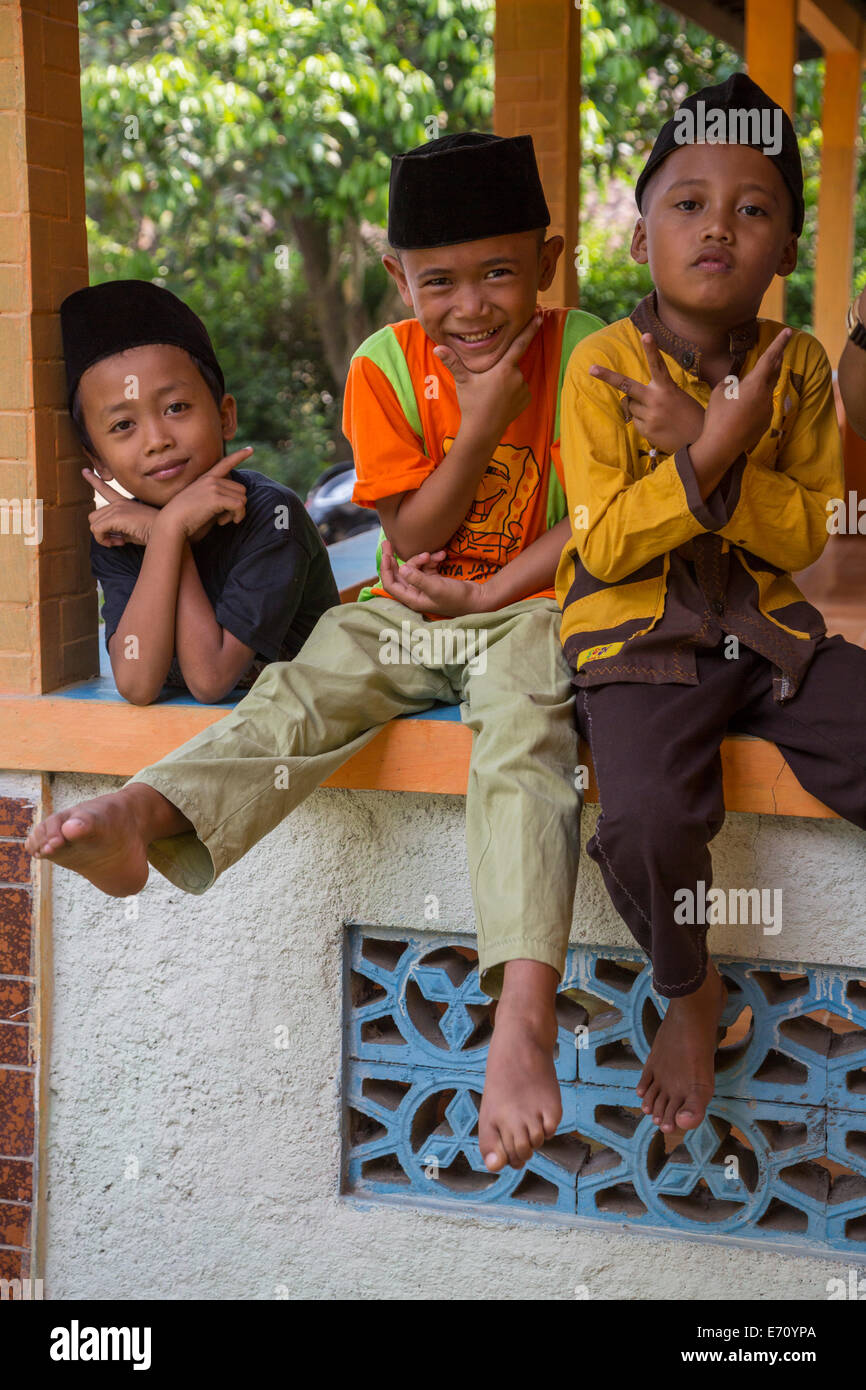 Borobudur, Java, Indonesia. Gesti indonesiano. I ragazzi in attesa di venerdì a mezzogiorno preghiere alla moschea di quartiere. Foto Stock