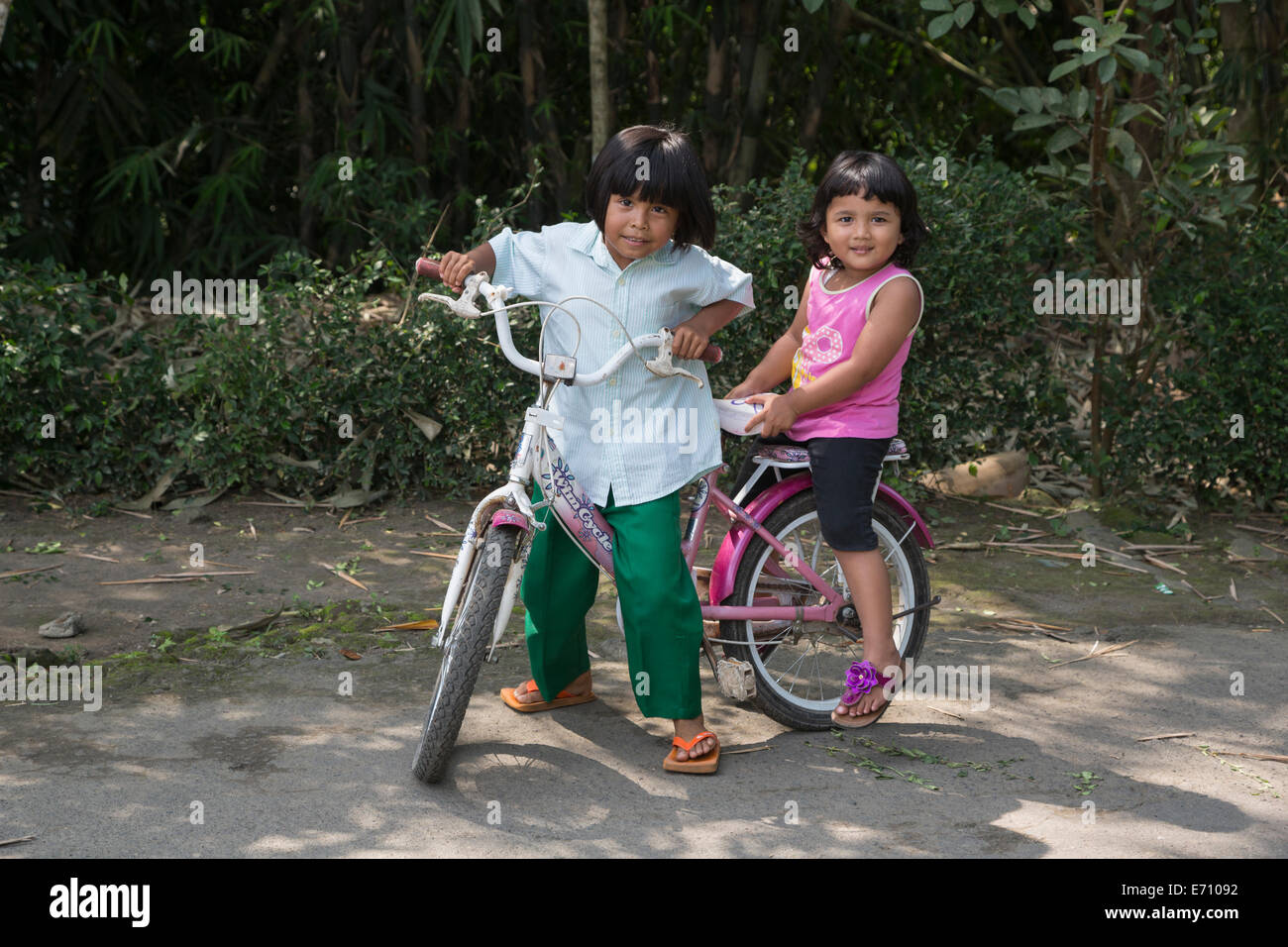 Borobudur, Java, Indonesia. Due giovani ragazze indonesiane su una bicicletta. Foto Stock