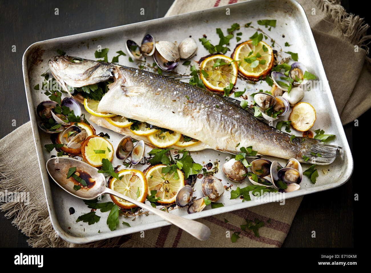 Vassoio da forno con pesce al forno ripiene con limone e erbe aromatiche Foto Stock