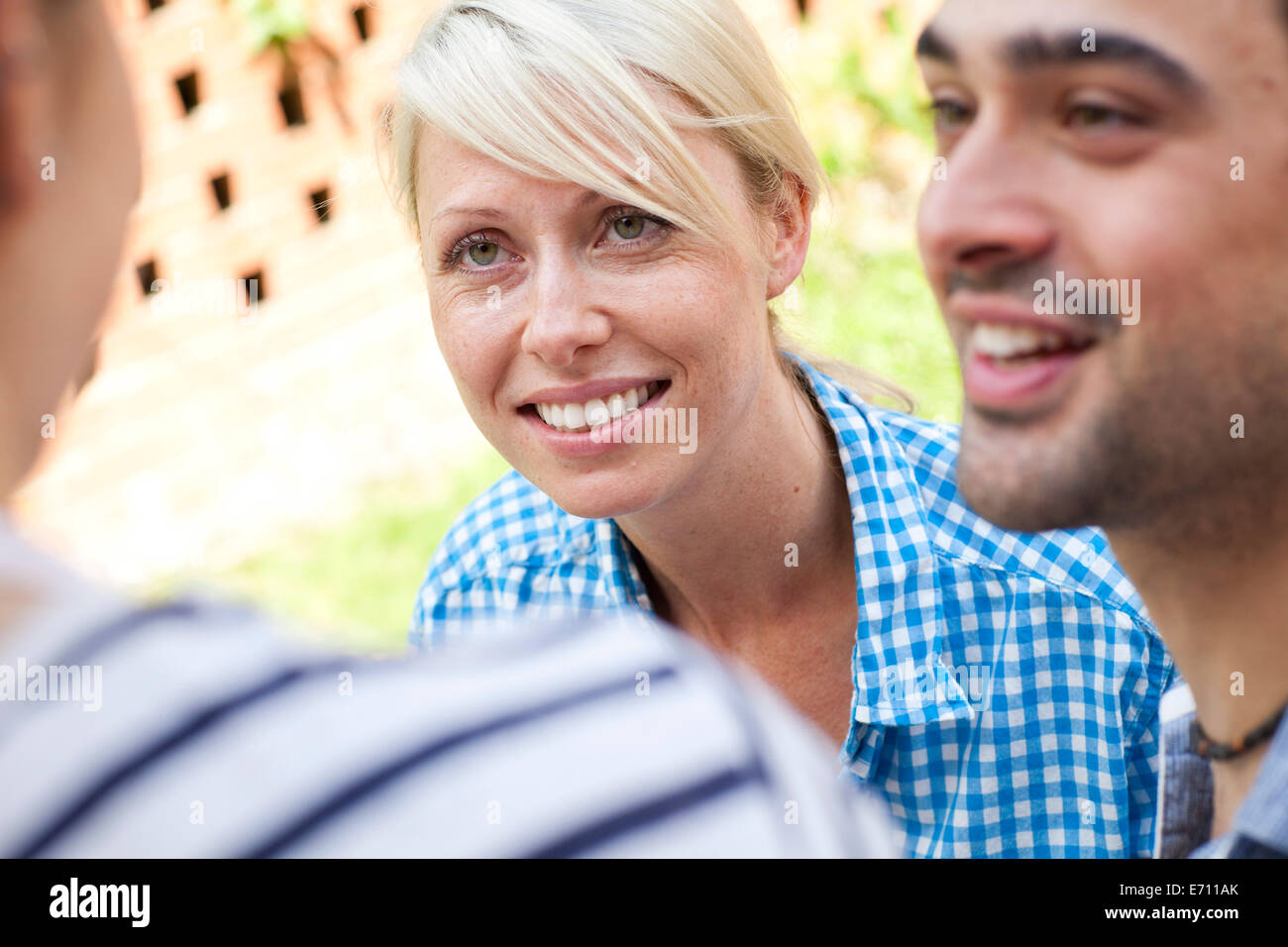 Chiudere fino a tre giovani amici adulti al party in giardino Foto Stock