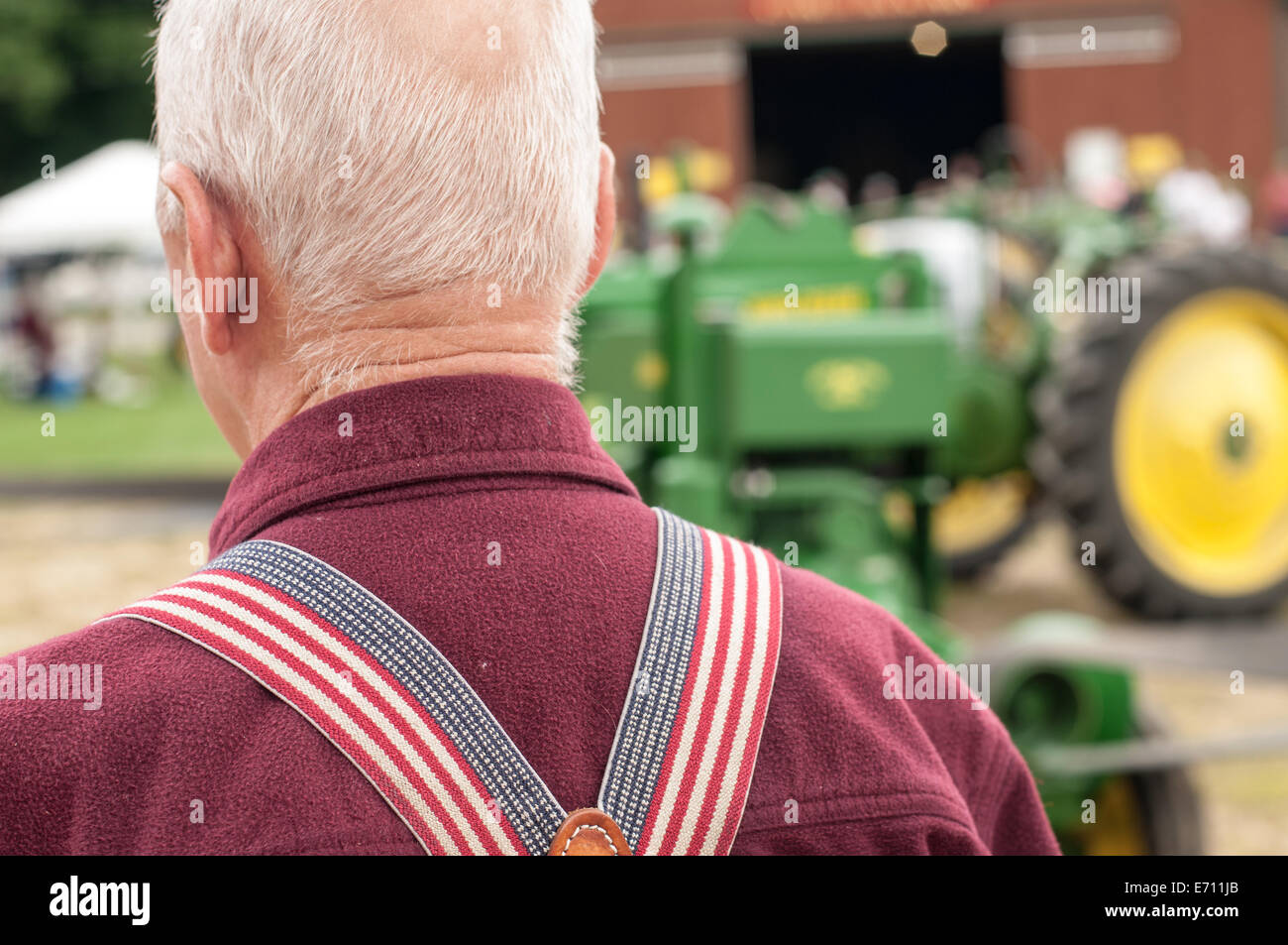 Un agricoltore che indossa bandiera americana autoreggenti a un trattore John Deere expo di nuovo a Boston, New Hampshire, Stati Uniti d'America. Foto Stock
