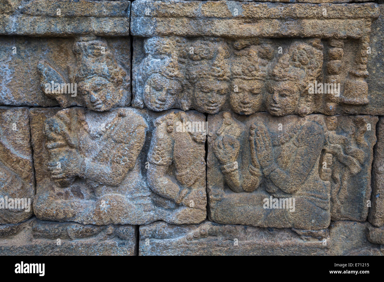 Borobudur, Java, Indonesia. Scene scolpite in pietra lungo i camminamenti del tempio. Foto Stock