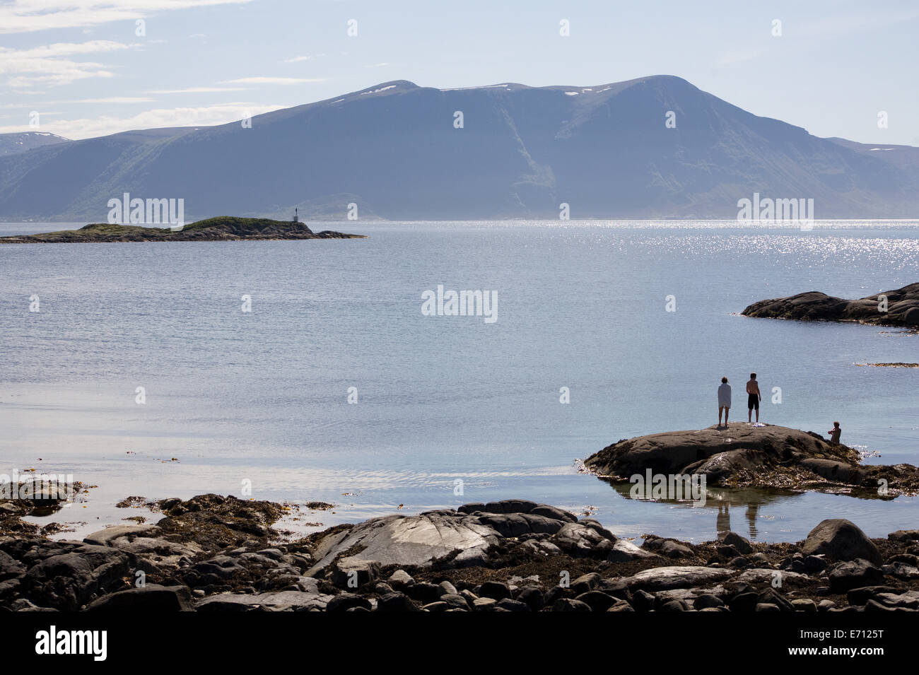 Tre persone in piedi sulle rocce del fiordo, Alesund, Norvegia Foto Stock