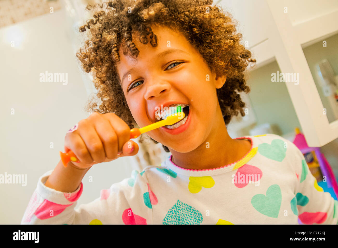 Ritratto di ragazza sorridente spazzolare i denti in bagno Foto Stock