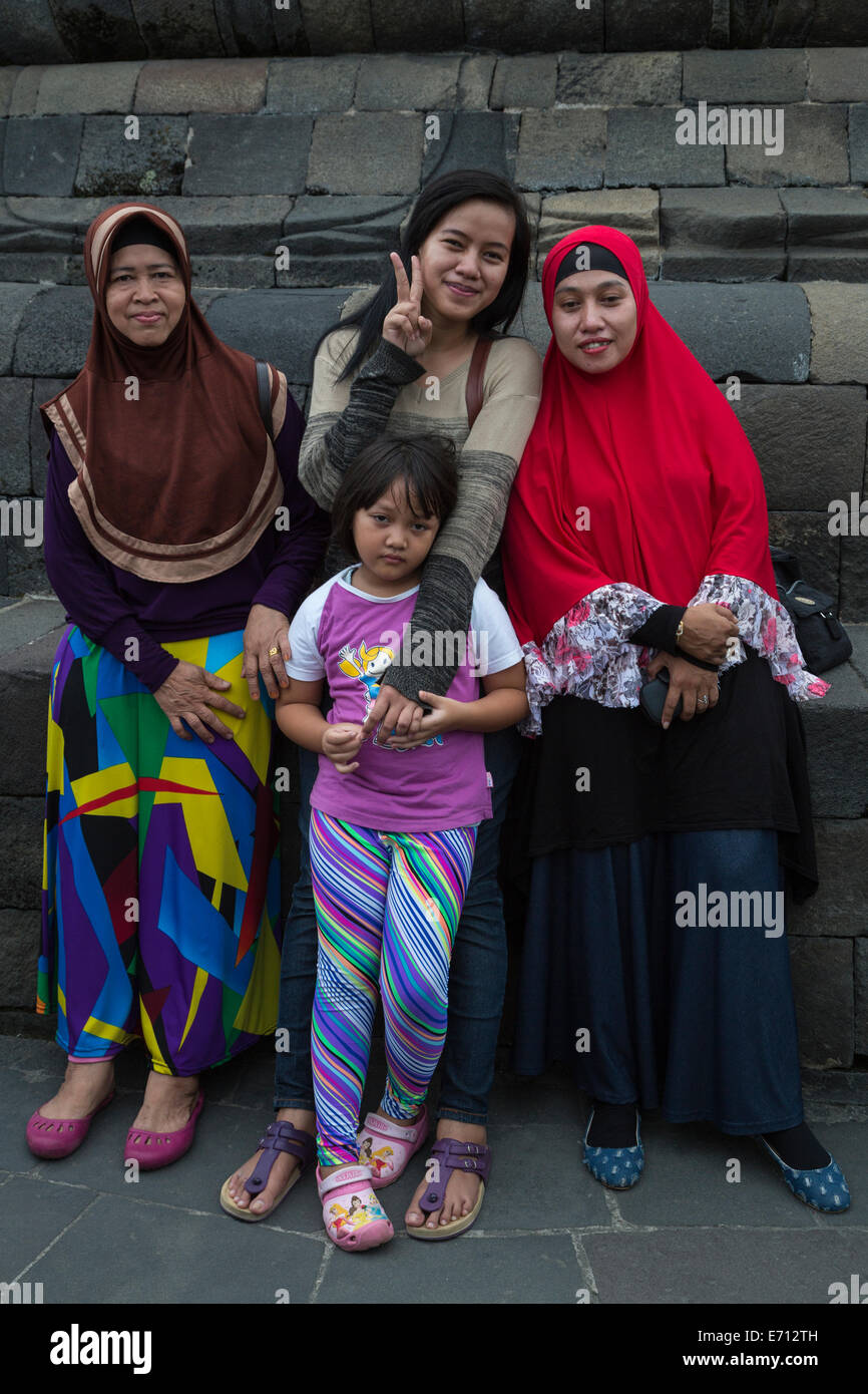 Borobudur, Java, Indonesia. Donne indonesiane in posa per la loro foto. Rendendo il V segno è un gesto comune. Foto Stock