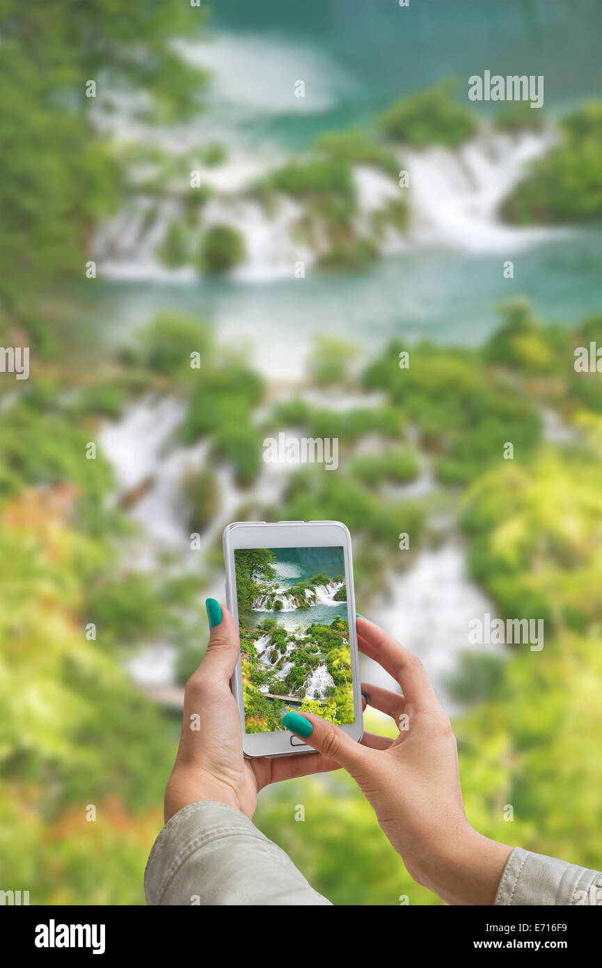 Ragazza di scattare le foto su un telefono cellulare nel Parco Nazionale dei Laghi di Plitvice in Croazia Foto Stock