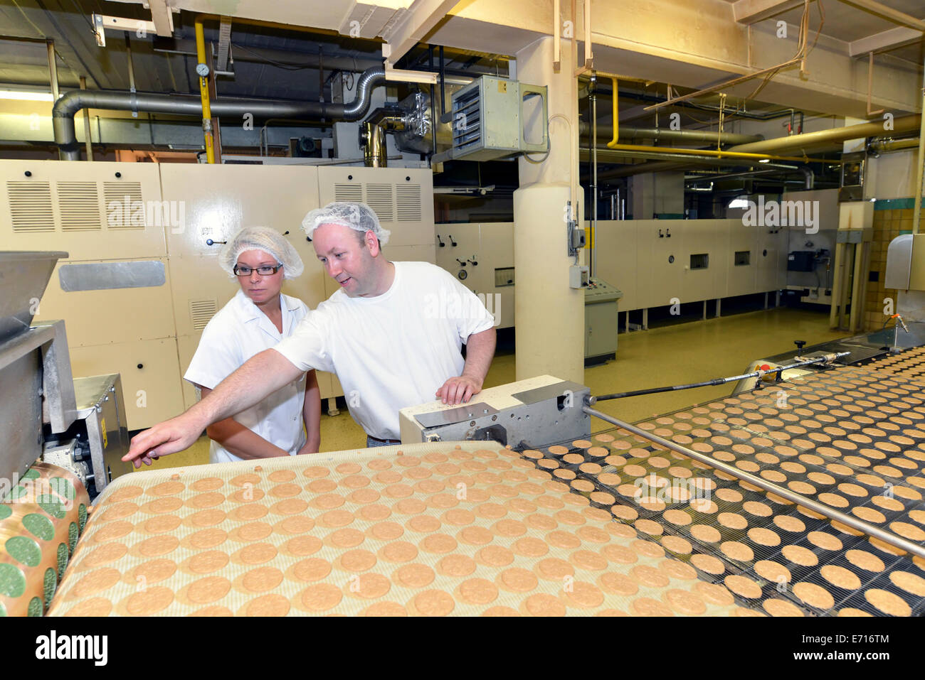 Germania, Sassonia-Anhalt, due lavoratori in linea di produzione con i cookie in una fabbrica di cottura Foto Stock