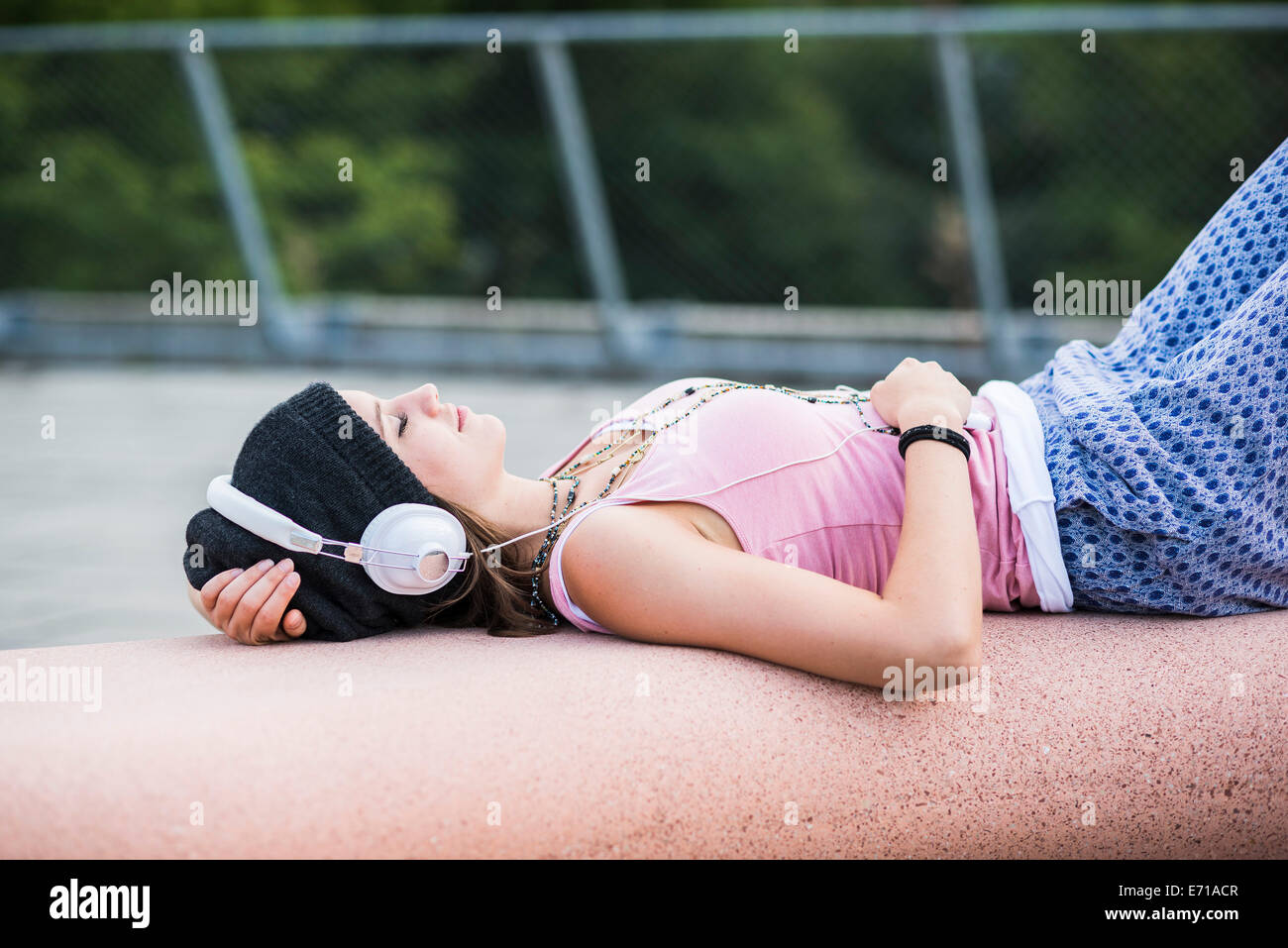 Sorridente ragazza adolescente con gli occhi chiusi ascoltando musica con le cuffie Foto Stock