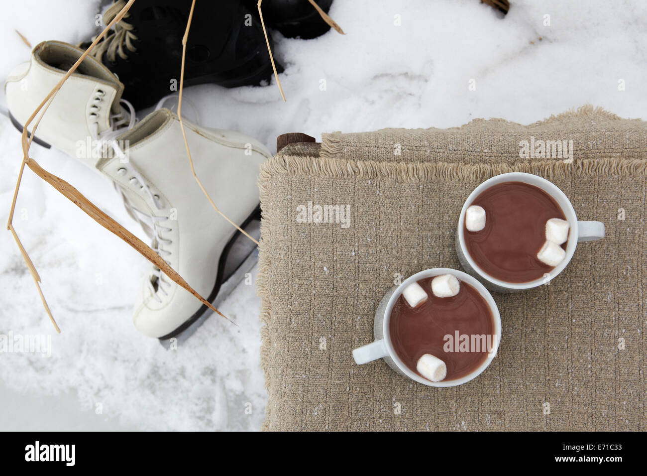 Cioccolata calda con marshmallows, hockey e figura pattini nel paesaggio invernale Foto Stock