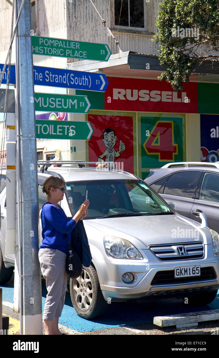 Donna di scattare una foto con un ipad in città sul lungomare di Russell sulla Baia delle Isole, Isola del nord, Nuova Zelanda. Foto Stock