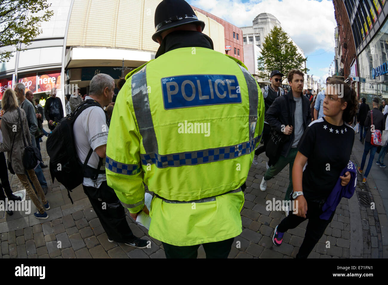 Un poliziotto in servizio nella affollata area dello shopping di Market Street a Manchester in una trafficata sabato Foto Stock
