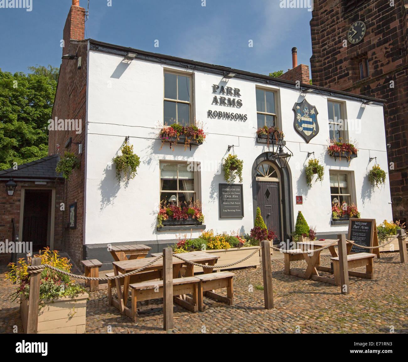 Vecchio pub Inglese con la bianca facciata dipinta, fiori colorati in scatole di finestra e area da pranzo esterna al villaggio di Grappenhall Foto Stock