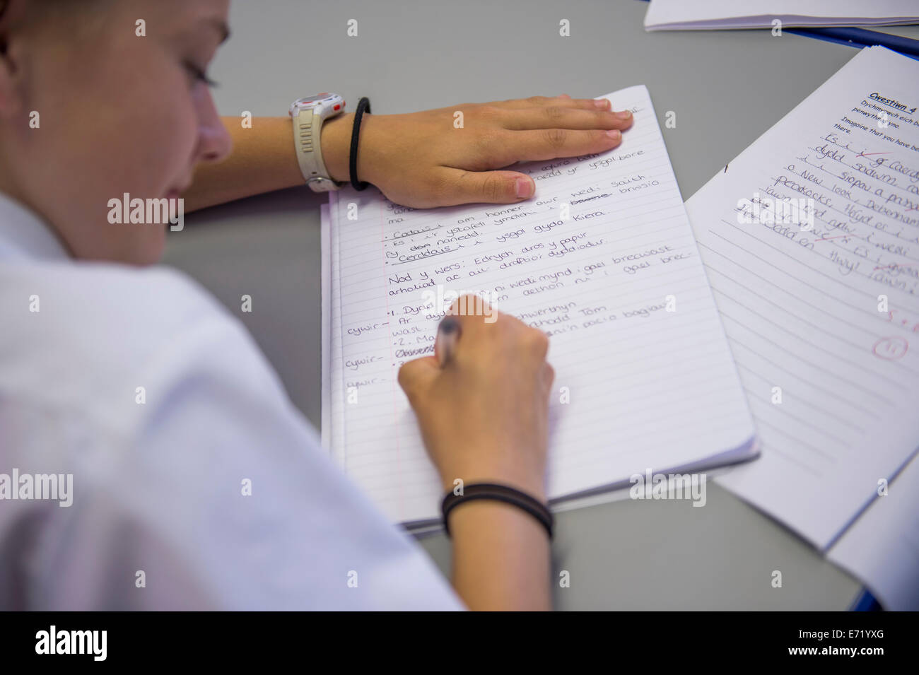 Istruzione secondaria Wales UK - un ragazzo la scrittura di note in una lingua gallese classe Foto Stock