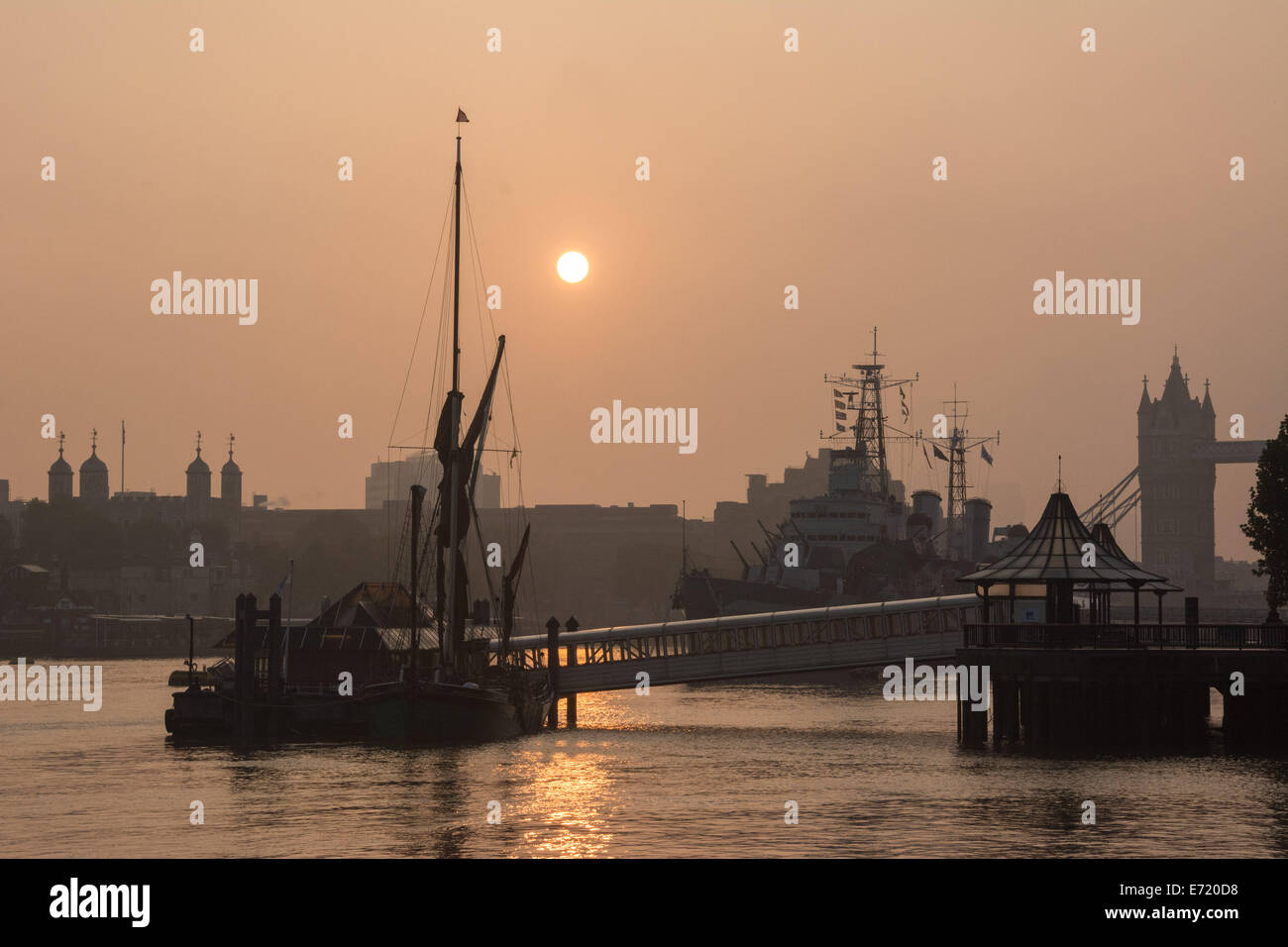 Londra, UK, 4 settembre 2014. Navi ormeggiate compresi HMS Belfast sono inondate di luce dorata come scie di Londra per una bella mattina nebbiosa. Credito: Patricia Phillips/Alamy Live News Foto Stock