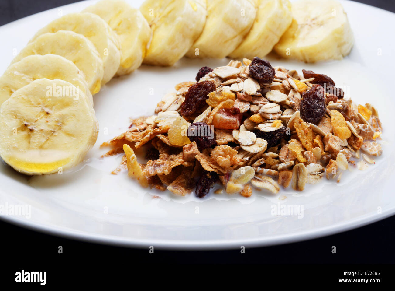 Cereali mescolati al latte con banana e rabboccato con il miele per la salute Foto Stock