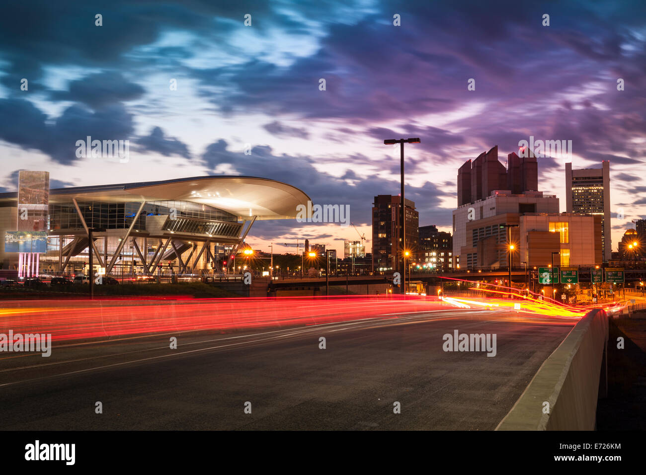 I percorsi del traffico streak passato il Boston Convention & Exhibition Center, come il sole tramonta sul porto distretto di Boston, Massa Foto Stock