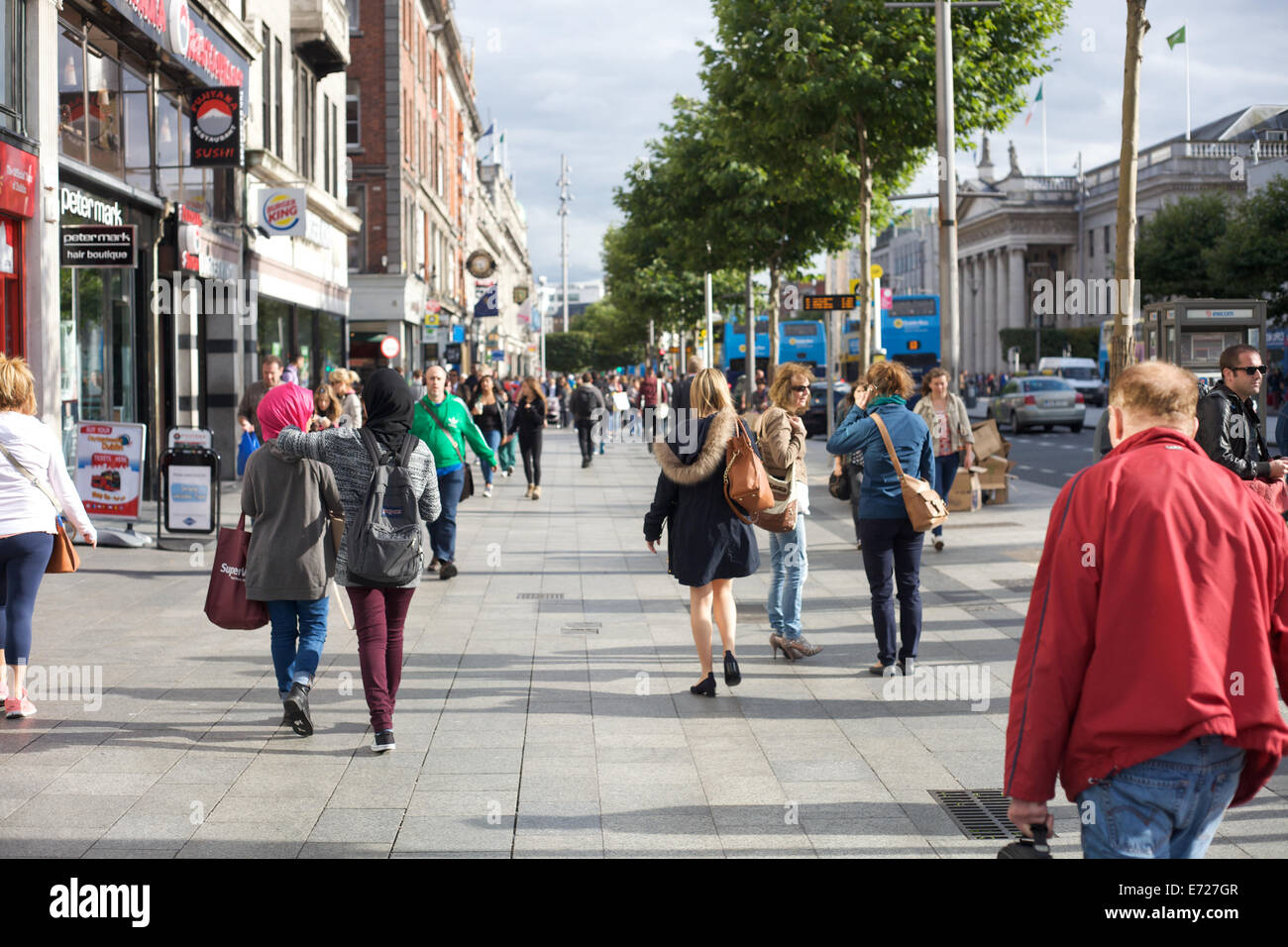 Persone che camminano giù O'Connell Street nella città di Dublino, Irlanda Foto Stock