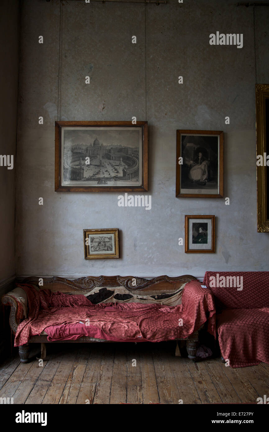 L'interno di una vecchia casa con mobili vintage e vecchie cornici appese alle pareti. Foto Stock