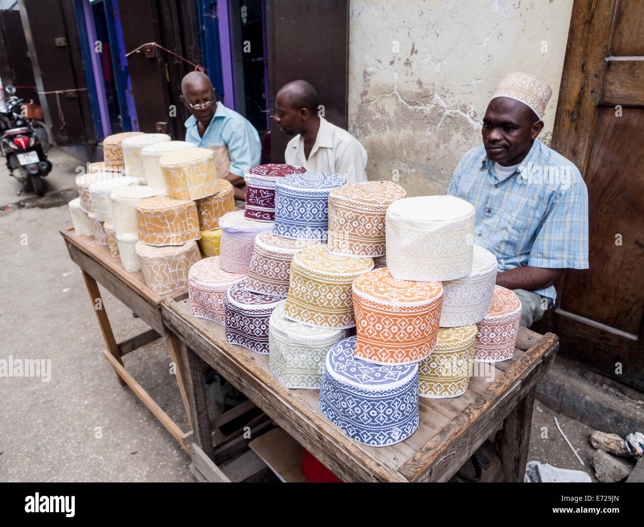 Gente che vende tazze musulmano chiamato taqiyah su uno stand nel mercato Darajani in Stone Town a Zanzibar. Foto Stock