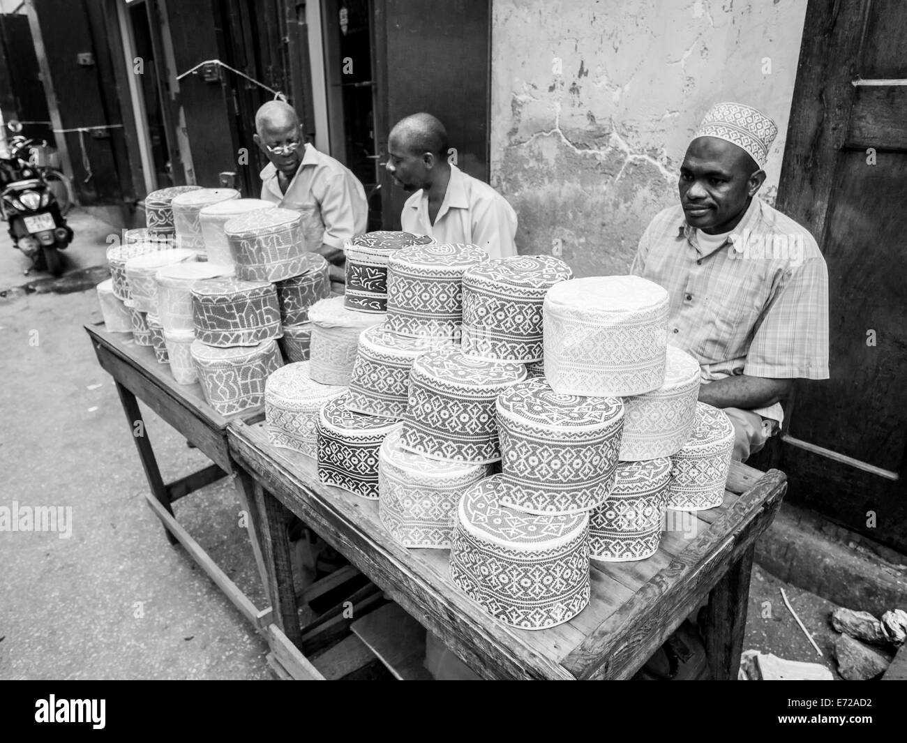 Gente che vende tazze musulmano chiamato taqiyah su uno stand nel mercato Darajani in Stone Town a Zanzibar. Foto Stock