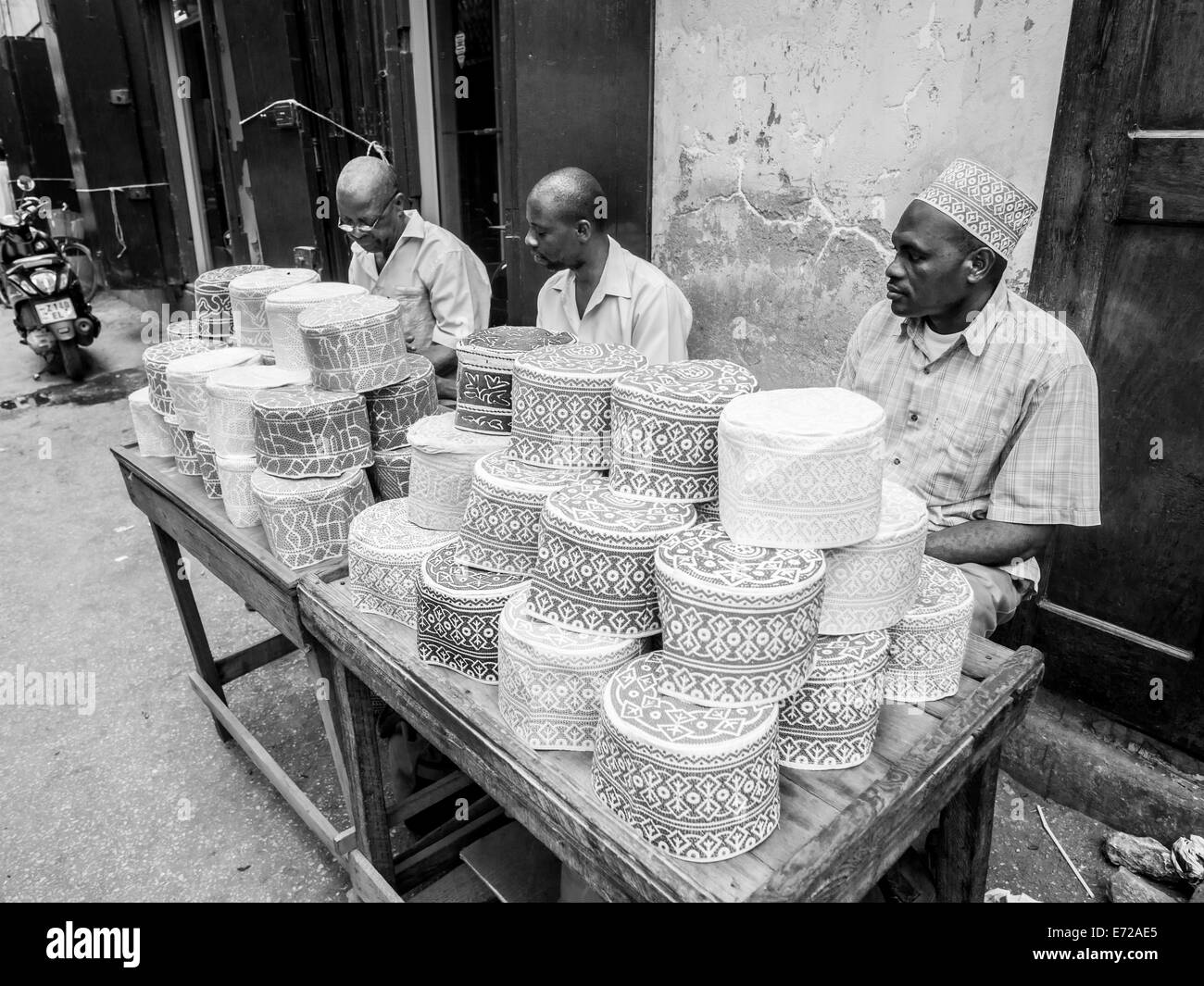Gente che vende tazze musulmano chiamato taqiyah su uno stand nel mercato Darajani in Stone Town a Zanzibar. Foto Stock