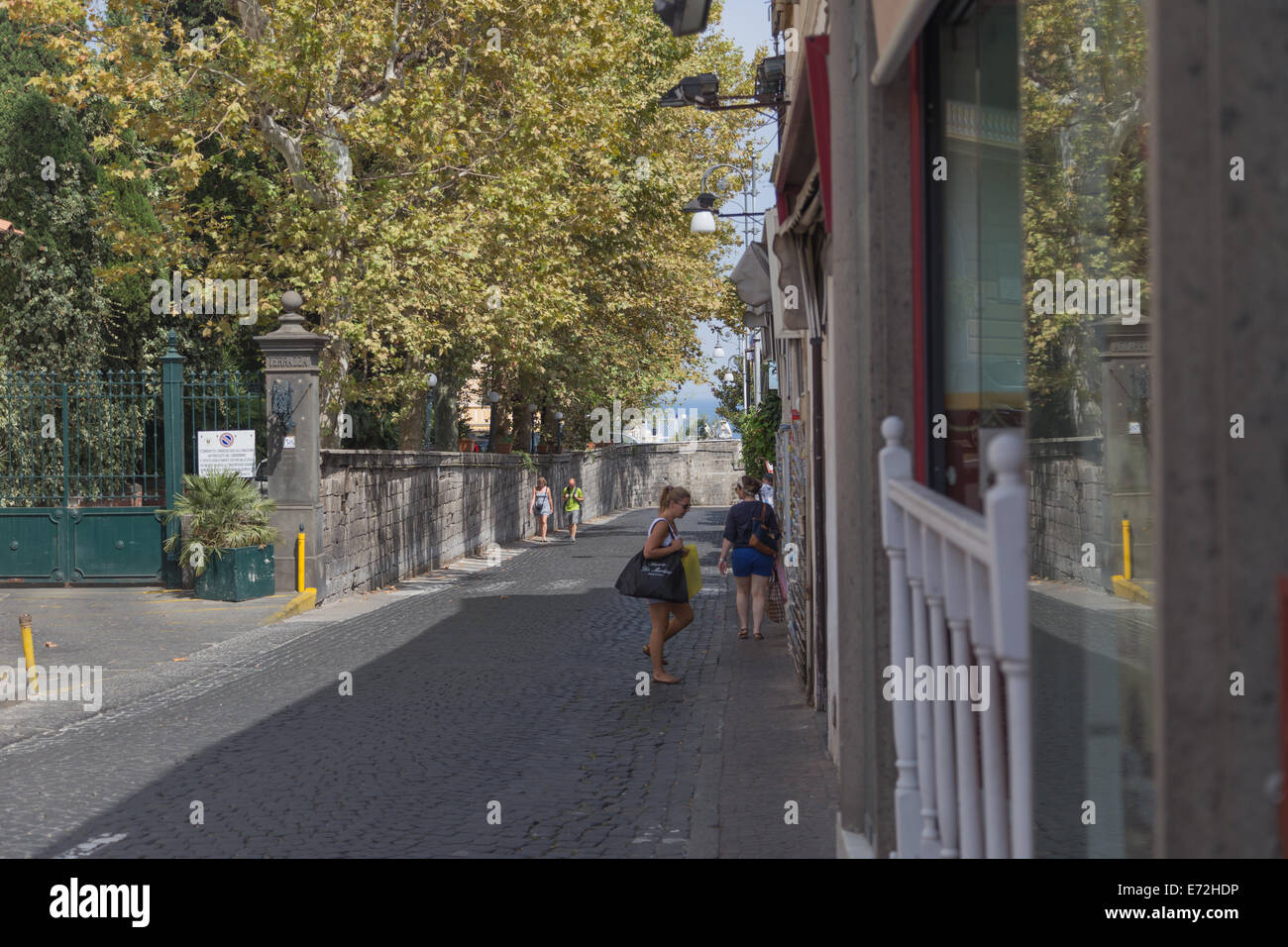 Due amanti dello shopping a piedi lungo una strada tranquilla verso il mare nella città italiana di Sorrento. Foto Stock