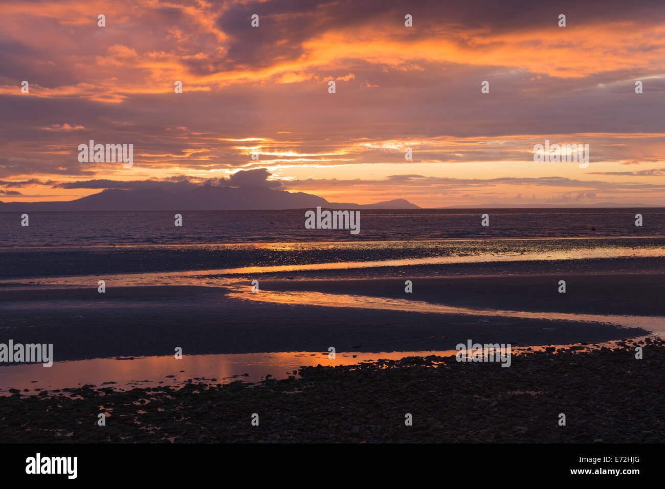 La vista da Prestwick promenade come il sole tramonta dietro l'isola di Arran in Scozia. Foto Stock