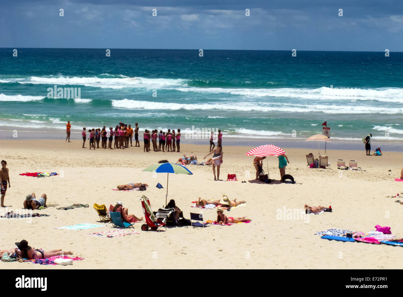 Gli amanti del sole per godersi la spiaggia e acqua sulla spiaggia principale sulla Gold Coast australiana Foto Stock