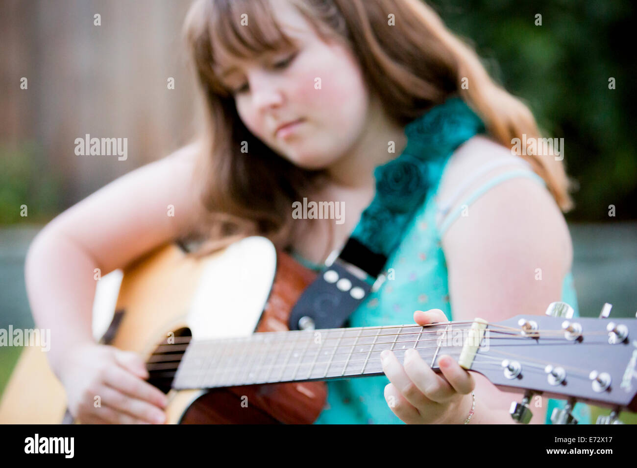 Ragazza adolescente (13-15) a suonare la chitarra Foto Stock
