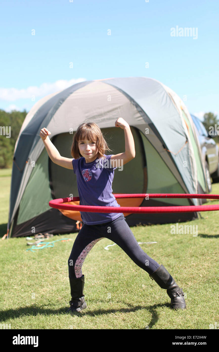 La ragazza (10-12) nella parte anteriore della tenda di filatura ad anello in plastica Foto Stock