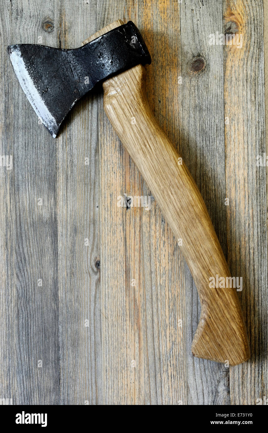 Ax con manico in legno di quercia su uno sfondo di legno Foto Stock