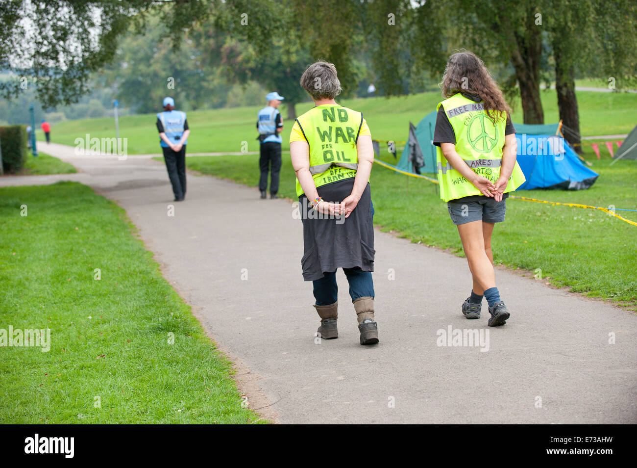 Newport, Regno Unito. 5 settembre 2014. Due OLP's (Polizia Liason ufficiali) a piedi passato l'Accampamento della pace a Tredegar Park seguita da due Accampamento della Pace organi ufficiali. La sicurezza della NATO che coinvolge oltre 9.000 funzionari di polizia da tutte le sezioni di Inghilterra e Galles è il più grande mai ed è stato uno di un delicato equilibrio tra le forze di polizia, residenti e Anti guerra contestatori. Accampamento della pace richiede una politica di attenzione quando si parla di OLP come si è affermato che esse sono state altamente addestrati come raccoglitori di intelligence. Credito: Graham M. Lawrence/Alamy Live News. Foto Stock