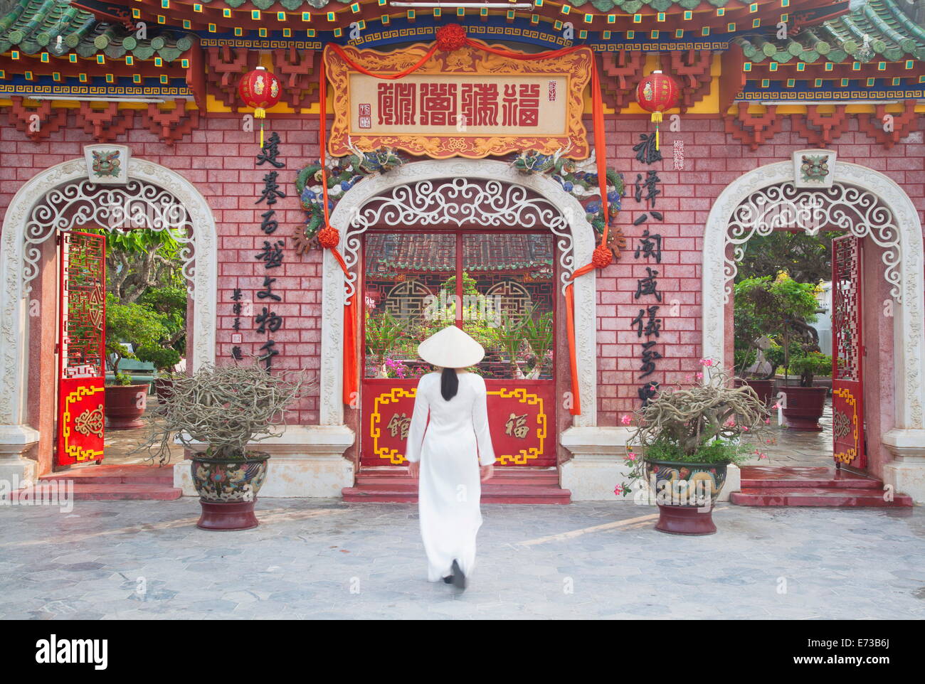 Donna che indossa Ao Dai abito a Phouc Kien Assembly Hall, Hoi An, sito UNESCO, Quang Nam, Vietnam, Indocina, Asia sud-orientale, Asia Foto Stock