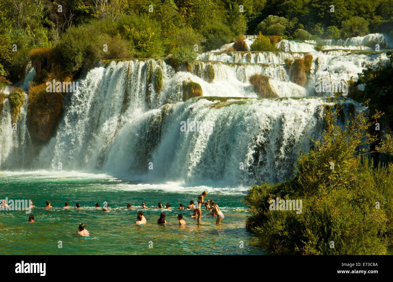 KRKA, Croazia - agosto 2014. I turisti vasca sotto le cascate di Krka nel Parco Nazionale di Krka, grande attrazione vicino a Sibenik. Foto Stock